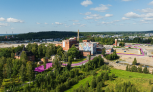 Dronekuva Hiedanrannasta kesällä 2024 Sellupuiston suunnasta kohti Tehdasta. Kuvassa opastetaan ajamaan Lielahden kartanon parkkipaikalle.